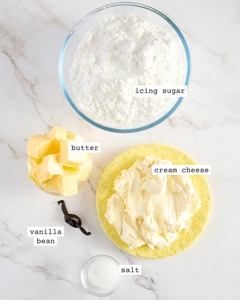 Labelled vanilla cream cheese frosting ingredients on a marble benchtop.