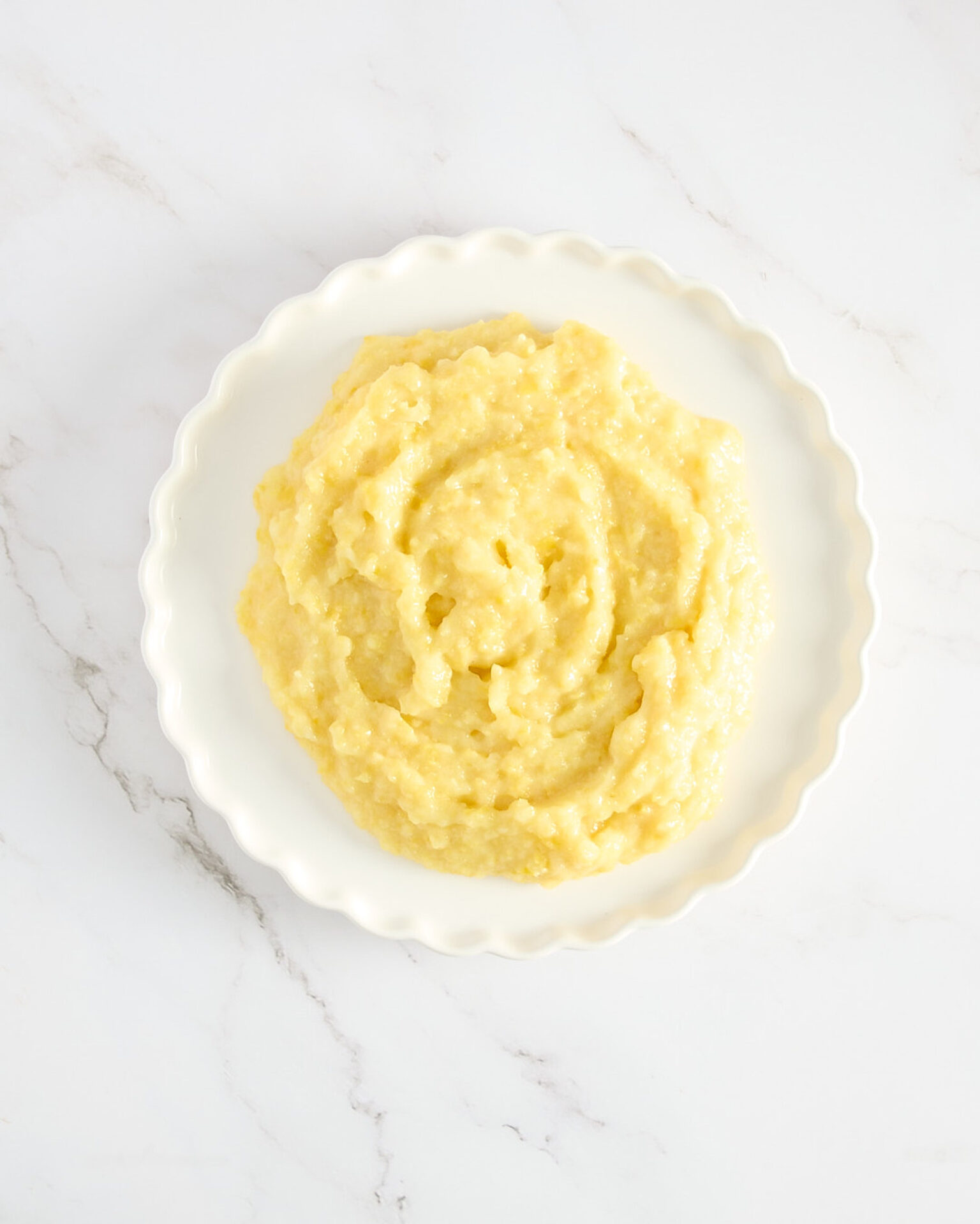 Pureed boiled lemon in a white ceramic dish on a marble bench.