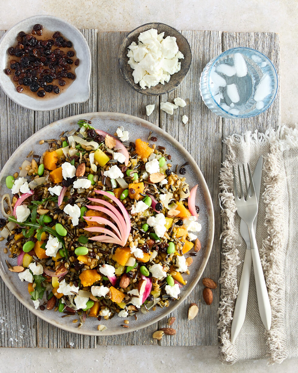 Kitchen Sink Pumpkin Salad with side dishes of currant in vinegar and goat cheese completes the place setting.