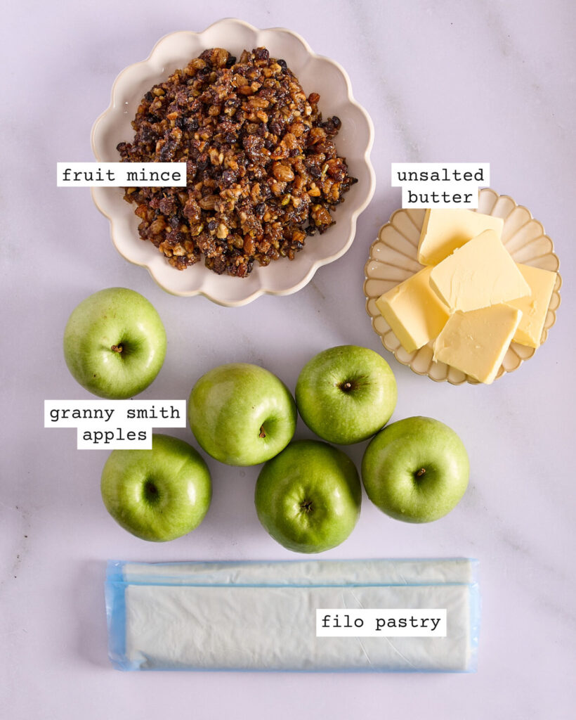 Labelled ingredients for easy apple fruit mince tarts on a white marble bench.