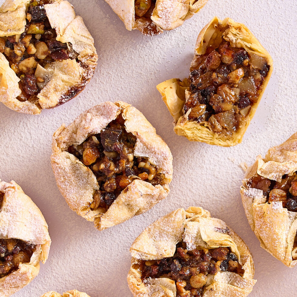 Easy apple fruit mince filo tarts dusted with icing sugar on a white bench.
