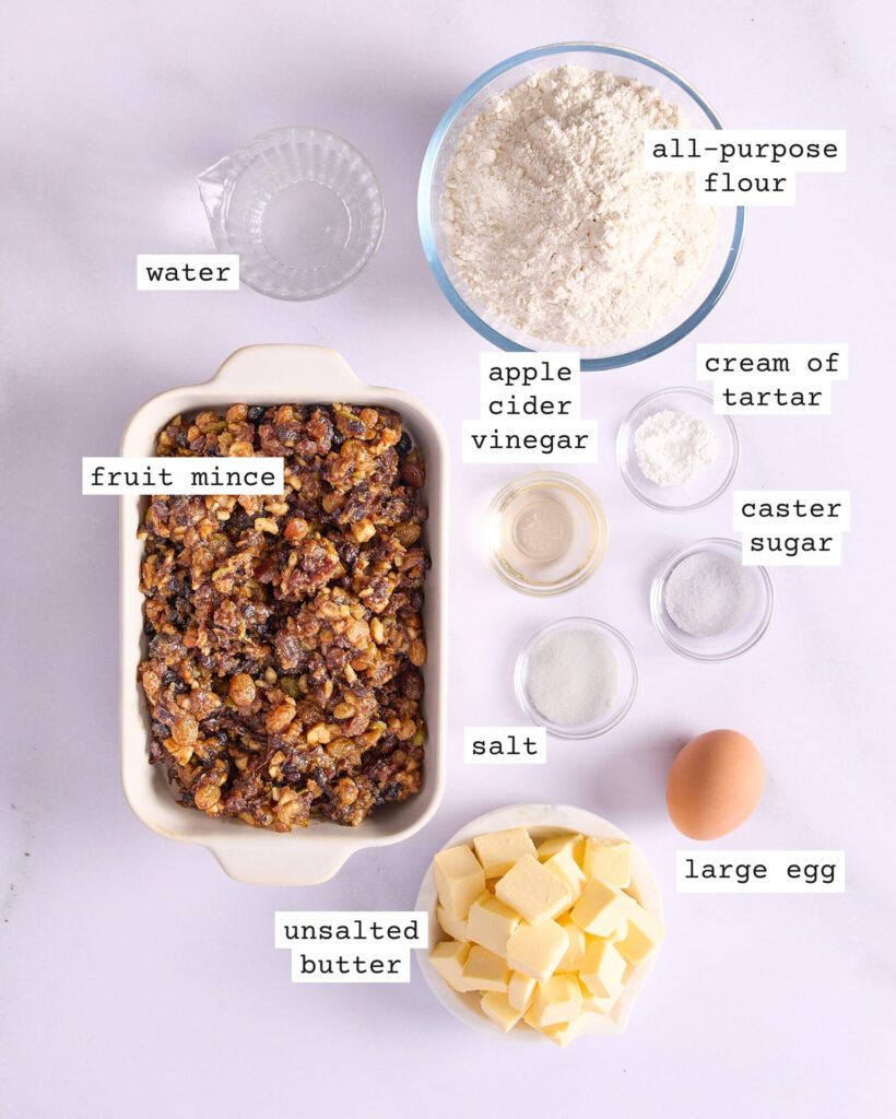 Labelled ingredients for fruit mince tarts on a white bench.