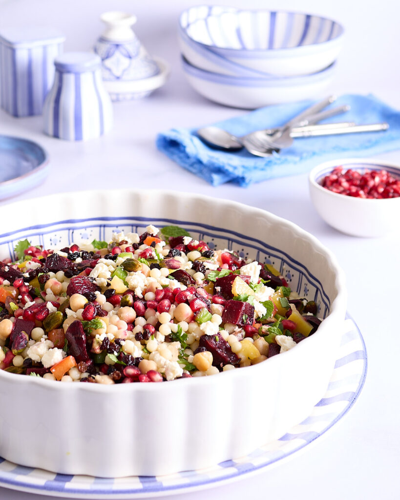 Moroccan kitchen sink salad ready to be served sitting amongst a blue and white table setting.