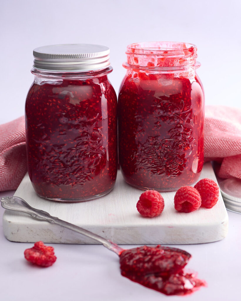 Two jars of raspberry jam ready to store and eat.