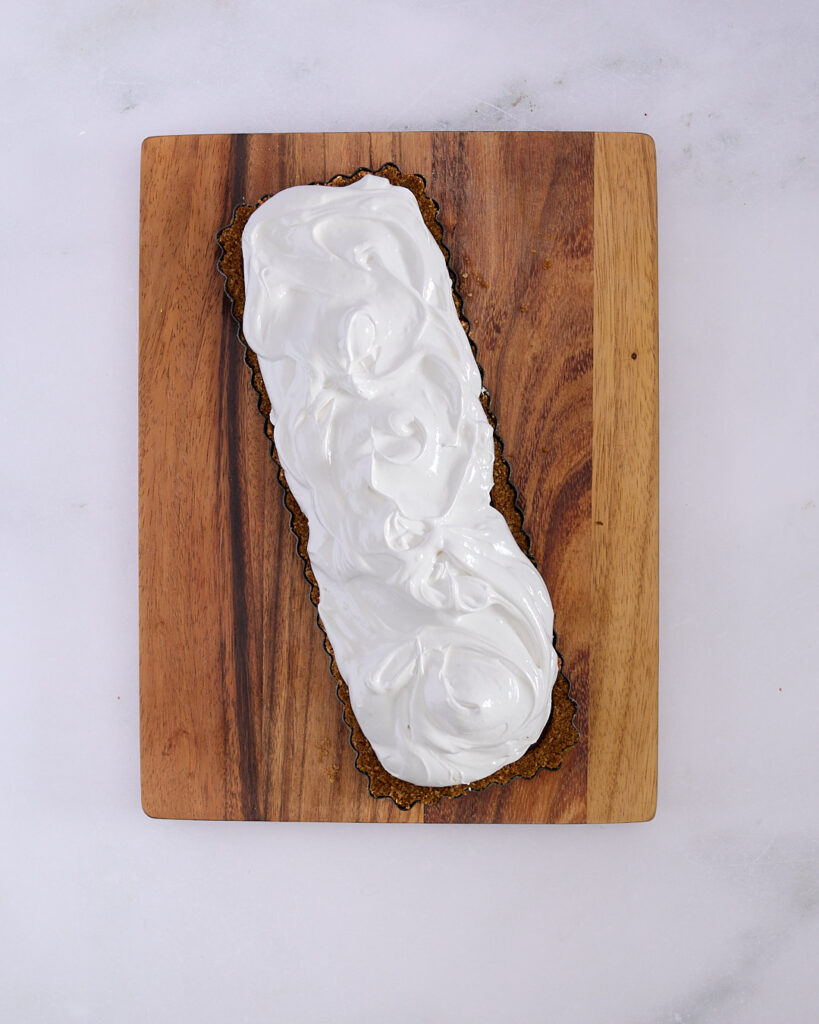 A chocolate raspberry tart topped with fluffy homemade marshmallow, swirled and ready for toasting.