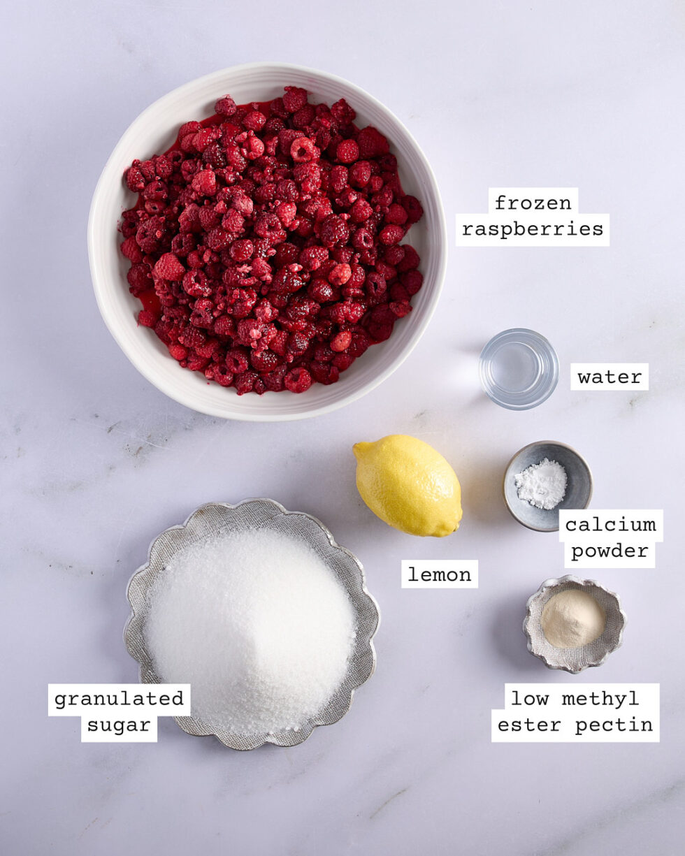 Low sugar Raspberry Jam ingredients on a white marble bench top.