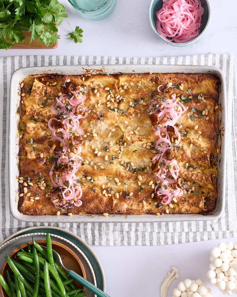 Golden baked cannelloni made with homemade pasta sheets—topped with pickled onions, pine nuts, and micro herbs.