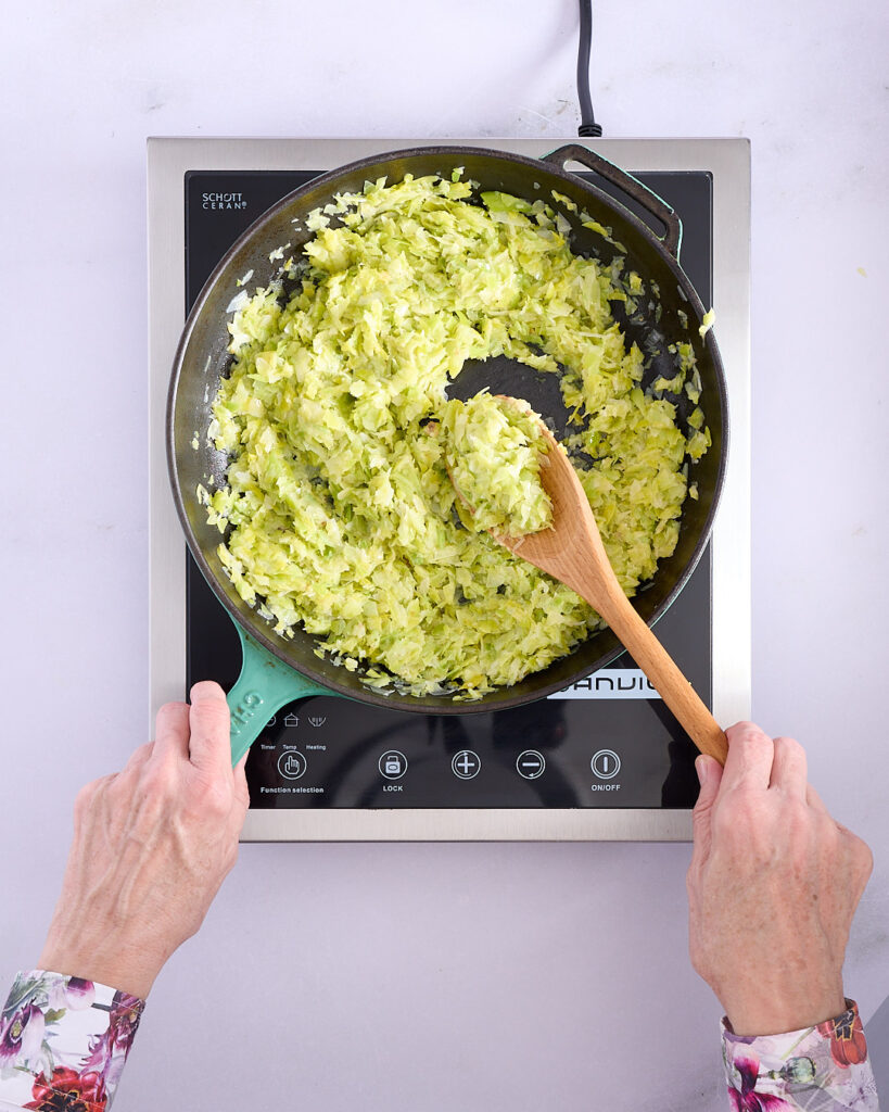 Sandra sautéing chopped leeks, garlic, and anchovies.