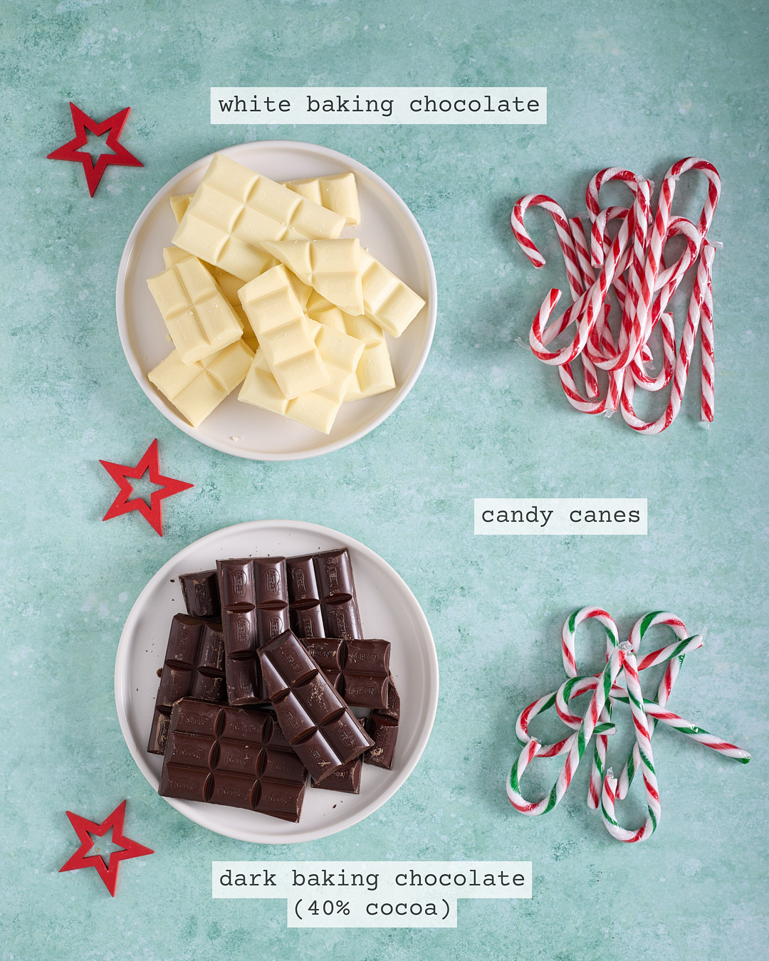 Overhead image of ingredients for Candy Cane Peppermint Chocolate Bark: plates of chopped white baking chocolate and dark baking chocolate (40% cocoa) with labelled text, alongside red-and-white and green-striped candy canes on a pale green background with red star decorations.