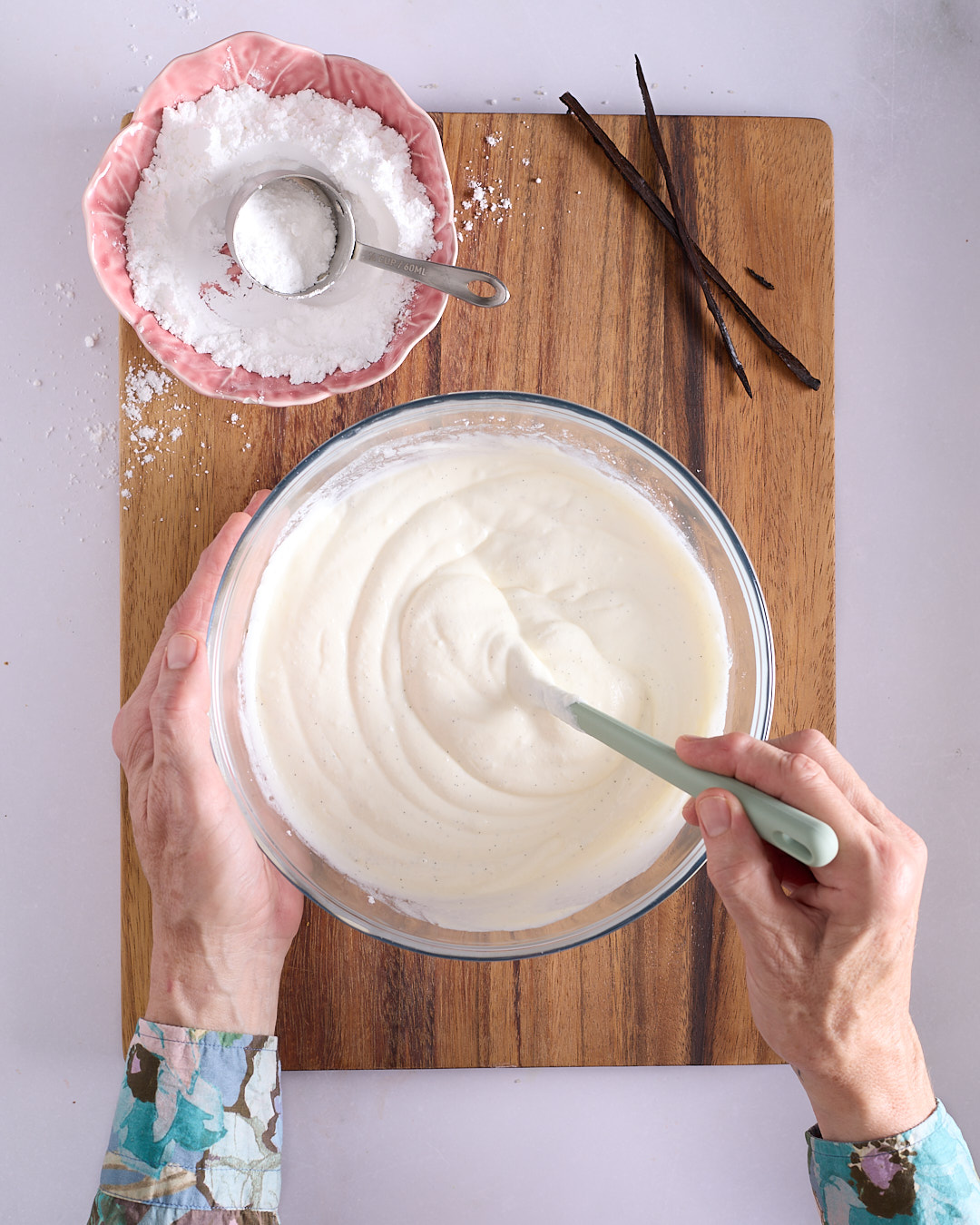 Sandra using a spatula to stir vanilla bean seeds into a mixture of mascarpone and Greek yoghurt.