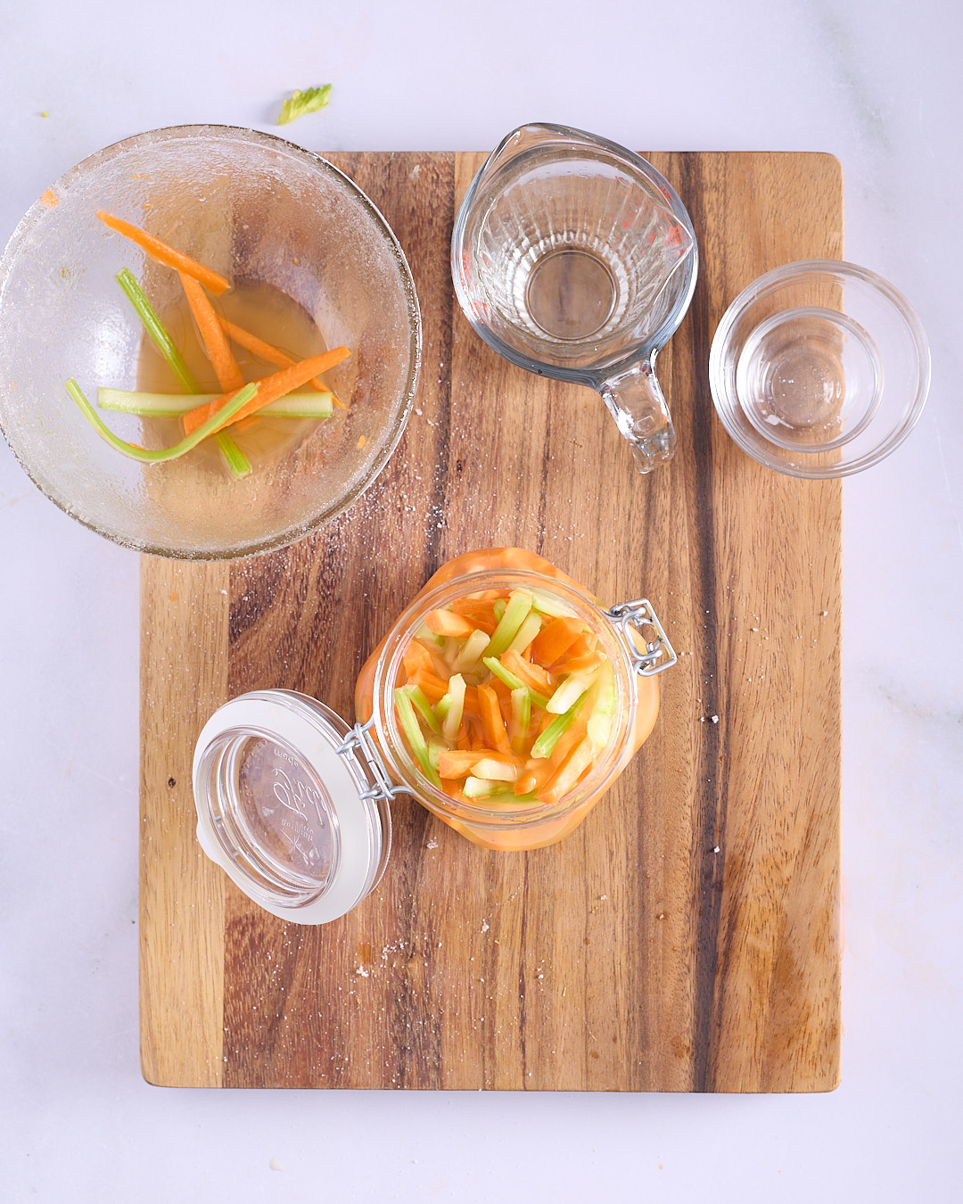 Quick pickled carrot and celery batons in a clip-top glass jar with rice wine vinegar brine, a simple Đồ Chua-style pickle for Vietnamese-style pork and chicken meatloaf bánh mì.